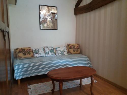 a bed in a room with a table and a stool at Le grenier d'alice in Thurageau