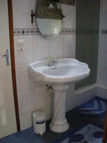 a white sink in a bathroom with a mirror at Le grenier d'alice in Thurageau