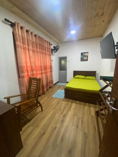 a bedroom with a green bed and a chair at The Ceylon Olive Resort in Katunayaka