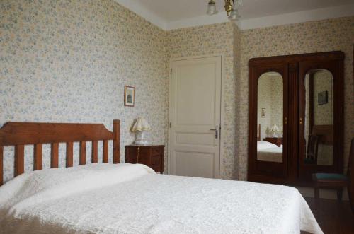a bedroom with a white bed and a mirror at La maisons des tilleuls in Thurageau