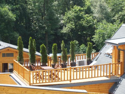 a large wooden deck with chairs and trees at Chalets under Falcon Ridge in Česká Ves