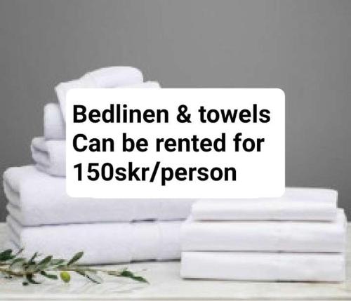 a stack of white towels on a table with a stack of books at Wallander's hometown, close to beach & café in Ystad