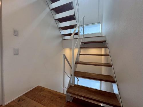 a staircase in a room with a white wall at ura アルコバレーノ奉還町 in Okayama