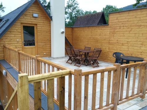 a deck with chairs and a table on a house at Chalets under Falcon Ridge in Česká Ves