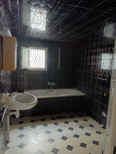 a bathroom with a bath tub and a sink at Salmane Villa in Nabeul