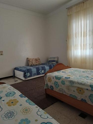 a bedroom with two beds and a window at Salmane Villa in Nabeul