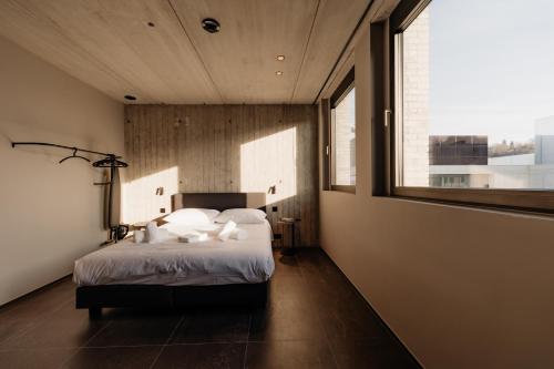 a bedroom with a bed and a large window at Coliving - Bord de Meuse - L'échappée Mosane in Oupeye