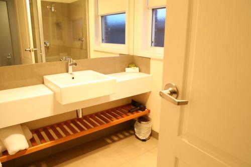 ein Badezimmer mit einem weißen Waschbecken und einem Spiegel in der Unterkunft Allansford Hotel Motel in Allansford