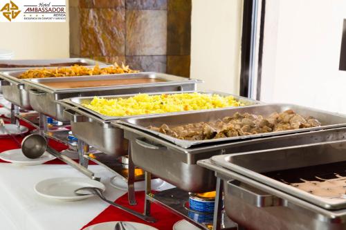 a row of trays of food in a kitchen at Hotel Ambassador Mérida in Mérida