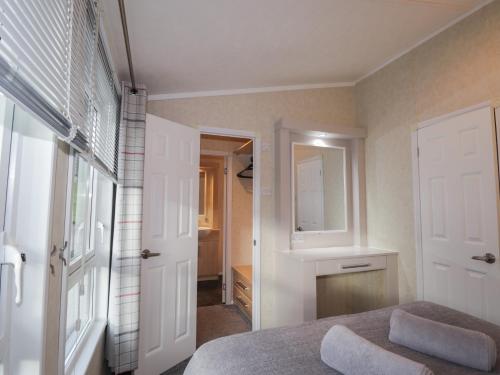 a bedroom with a bed and a sink and a mirror at Iona Lodge in Fort William