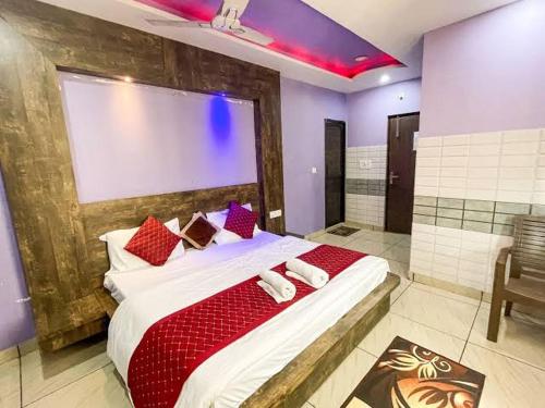 a bedroom with a large bed with red pillows at Hotel shiv shakti yatri niwas in Maihar