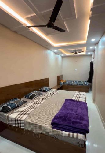 a bedroom with a bed with a ceiling fan at Hotel shiv shakti yatri niwas in Maihar