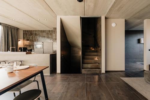 a kitchen with a table and a staircase in a room at Coliving - Bord de Meuse - L'échappée Mosane in Oupeye