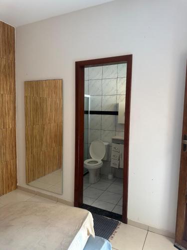 a bedroom with a mirror and a bathroom with a toilet at Casa de Praia 6 quartos e 4 suítes! in Valença