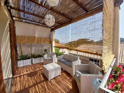 a screened in porch with couches and a clock at La casa accanto in Rio nellʼElba