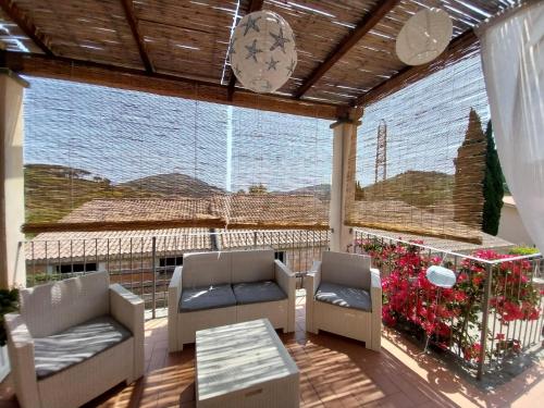 a screened in porch with two chairs and a table at La casa accanto in Rio nellʼElba