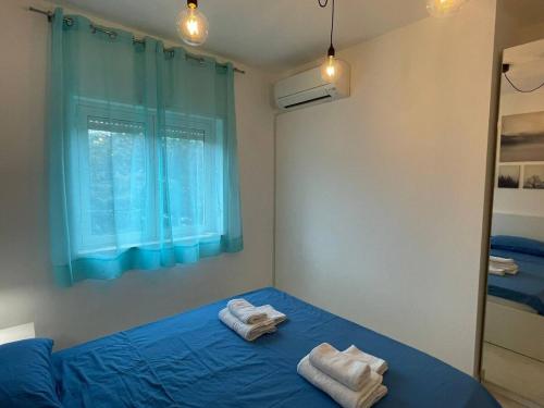 a bedroom with two towels on a bed with a window at Apartment - Pizzo Beach Club in Fondaco Vecchio