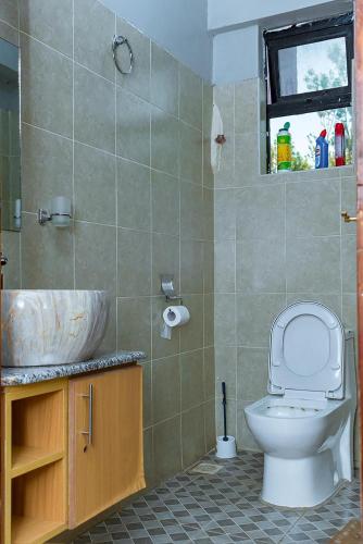 a bathroom with a toilet and a sink at Bethany Cushy Home Ltd in Kisii