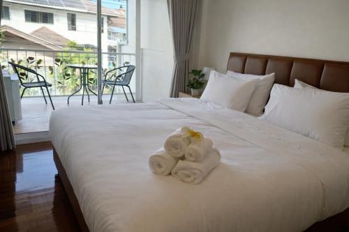 a bedroom with a white bed with towels on it at Family Hostel in Chiang Rai