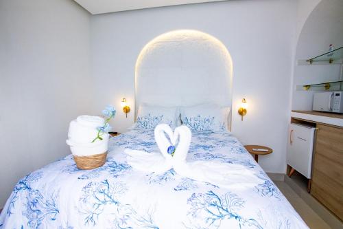 two swans sitting on a bed with towels at D'Blue Búzios Hotel Boutique in Búzios