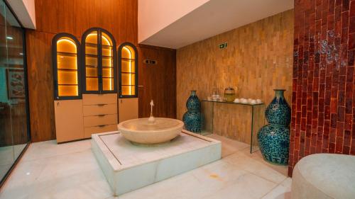 a bathroom with a large tub and vases on the wall at BRĂAT Hôtel in Rabat
