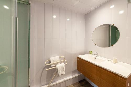 a bathroom with a sink and a mirror at Hotel De La Route Verte in Gérardmer