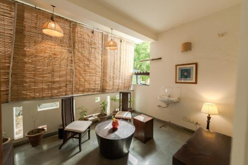 a living room with a table and a couch at Art KOTHI Gurgaon in Gurgaon