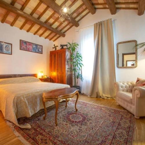 a bedroom with a bed and a table and a couch at Terrazza panoramica, 3 camere e 3 bagni in Collecorvino