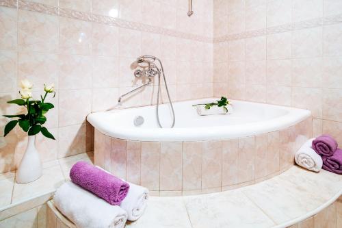 y baño con bañera y toallas púrpuras. en Economy Apartment Center, en Minsk