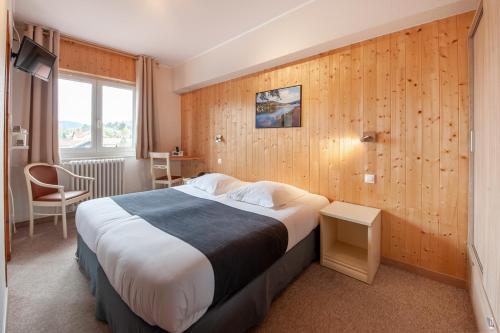 a hotel room with a bed and a window at Hotel De La Route Verte in Gérardmer