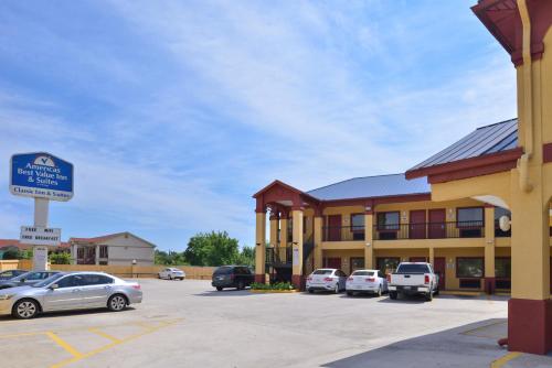 a building with cars parked in a parking lot at Americas Best Value Inn Downtown Houston in Houston