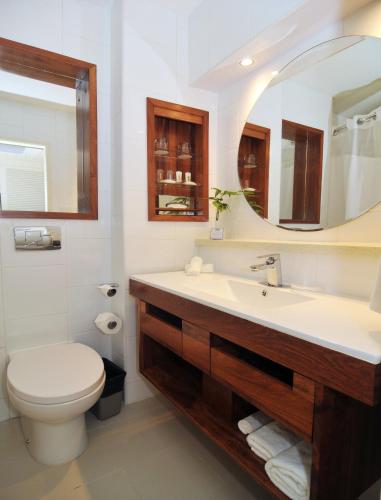 a bathroom with a sink and a toilet and a mirror at Holiday Inn Resort Vanuatu by IHG in Port Vila