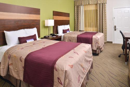 a hotel room with two beds and a desk at Americas Best Value Inn Downtown Houston in Houston