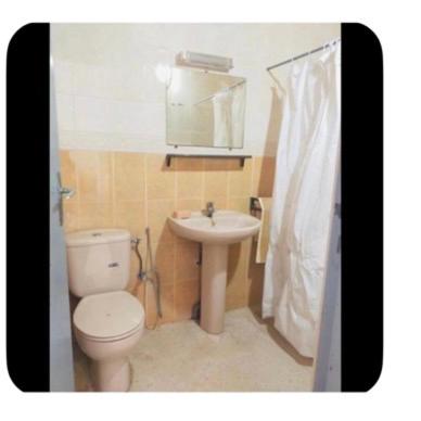 a bathroom with a toilet and a sink at Dar Khnata in Temara