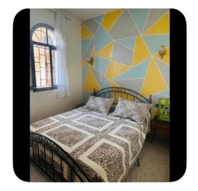 a bedroom with a bed with a geometric wall at Dar Khnata in Temara