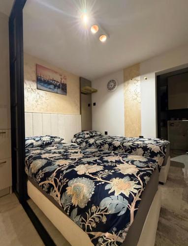a bedroom with a bed with a blue and white comforter at PORTA AUREA Našice in Našice