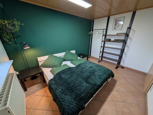 a bedroom with a bed with a green blanket and a ladder at Appartement Sonnenschein in Böhl-Iggelheim