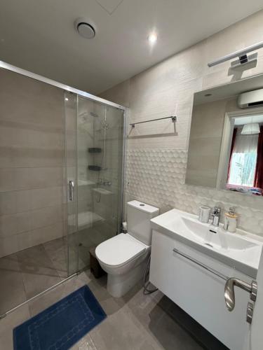 a bathroom with a toilet and a shower and a sink at Tala Rivera Paradise in Tala