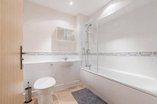 a white bathroom with a toilet and a shower at Roomspace Serviced Apartments - Cascades Court in London
