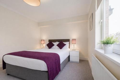 a bedroom with a large bed and a window at Roomspace Serviced Apartments - Cascades Court in London