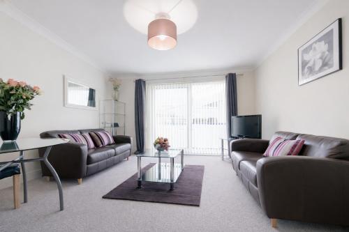 a living room with two couches and a table at Roomspace Serviced Apartments - Cascades Court in London