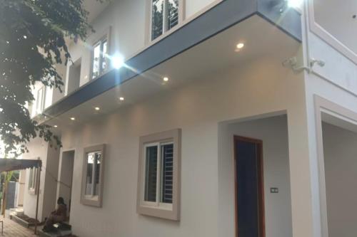a white house with a balcony on top of it at Dreamscape Rooms - Yelagiri in Yelagiri