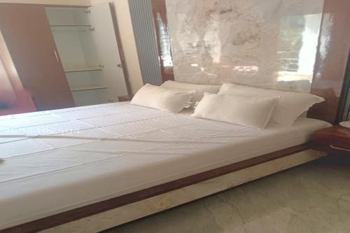 a large bed with white sheets and pillows at Dreamscape Rooms - Yelagiri in Yelagiri