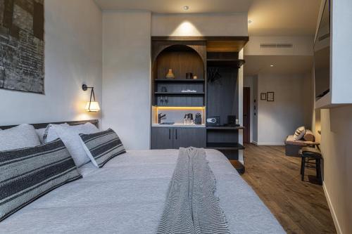 a bedroom with a large bed and a kitchen at WABI-SABI Hôtel Lorrain - Self Check-in in Nice