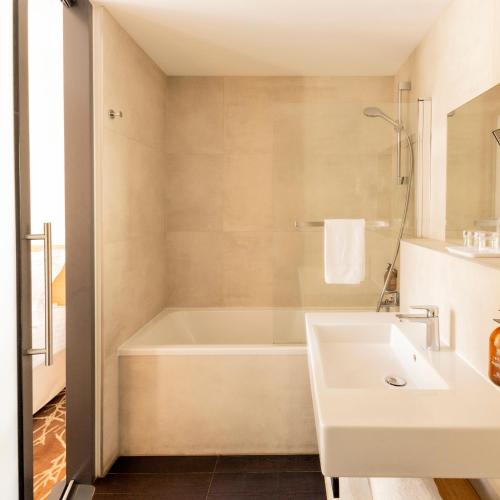 a bathroom with a tub and a sink at Grand Hotel Francais in Bordeaux