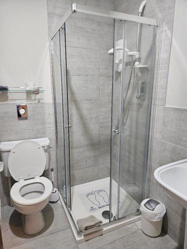 a bathroom with a shower with a toilet and a sink at Whitecroft B&B in Edinburgh