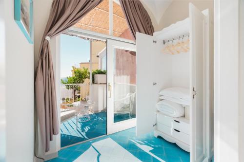 a bathroom with blue flooring and an open door at Villa La Tartana in Positano