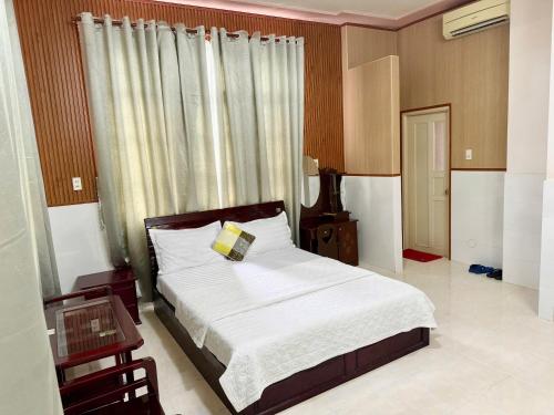 a bedroom with a bed and a table and a window at Thanh Cong Hotel in Sa Ðéc