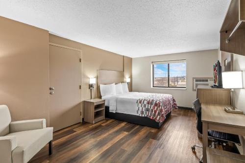 a hotel room with a bed and a desk at Red Roof Inn Ames in Ames