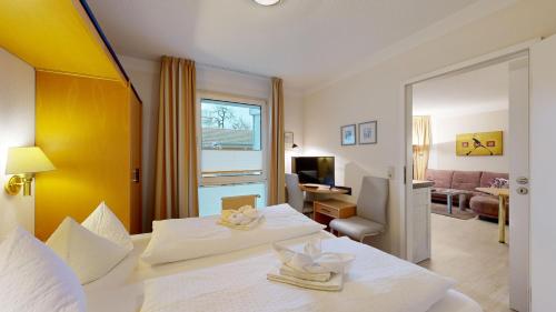 a hotel room with two beds and a living room at FeWo direkt am Strand , mit Balkon und seitlichem Meerblick, Haus Strelasund, Binz in Binz